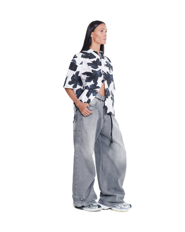 Printed camp shirt with open collar and short sleeves, black abstract print on white.
