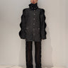 Elongated black jacket with stand collar, button front, and long sleeves