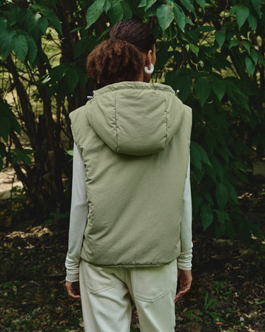 Back view of light green hooded puffer vest with hood and full-length zipper.