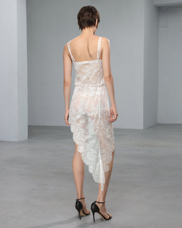 White lace slip dress with open back and spaghetti straps, draped skirt