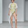 White lace dress with sheer overlay, neon-lime embroidered pattern, cape sleeves
