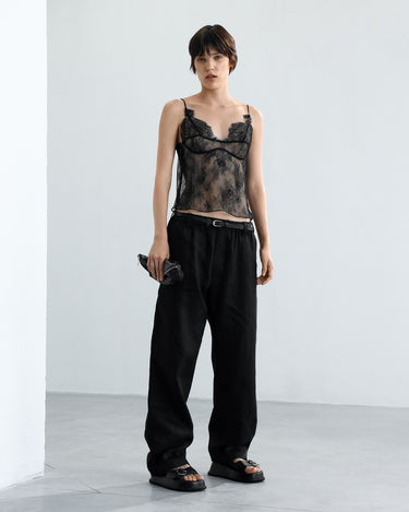 Black lace camisole top with spaghetti straps, worn over black trousers.