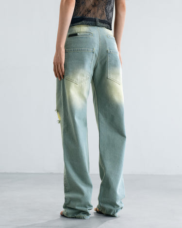 Light blue six-pocket jeans with distressed side rips and wide straight legs