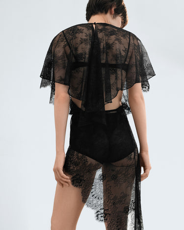 Back view of sheer black lace dress with open back and cape sleeves