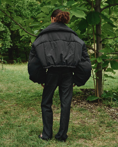 Black puffer winter jacket back view with turn-down collar and snap details