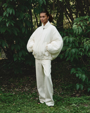 Cream padded bomber jacket with stand collar, zipper, elastic cuffs, and side pockets