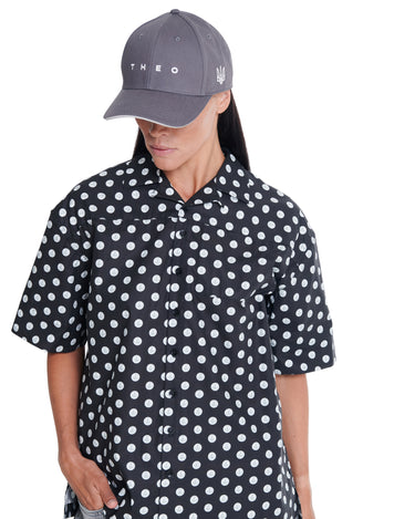 Black camp shirt with white circular print, short sleeves, button placket.