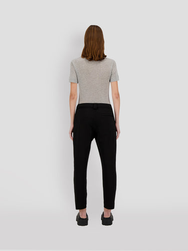 Black cropped sweatpants with drawstring waist; model wearing them from the back.