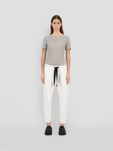 Cropped white sweatpants with black drawstring and Theo logo detail, front view